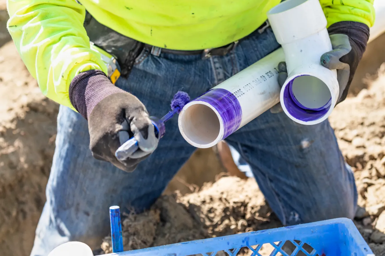 man applying purple solvent on the pipe